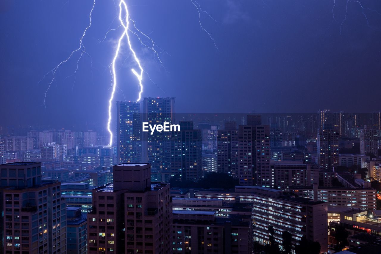 Aerial view of illuminated cityscape against sky at night