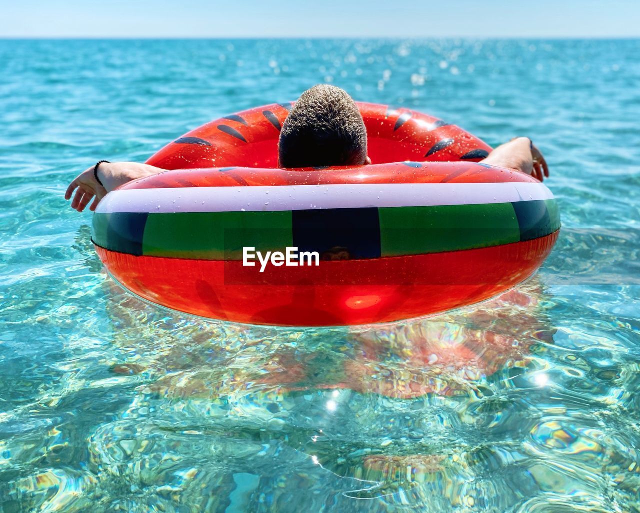 Red boat in swimming pool against sea