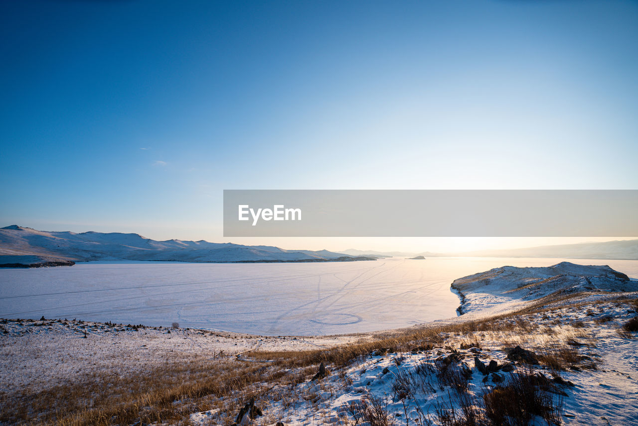 Scenic view of snowcapped mountains against clear sky during winter