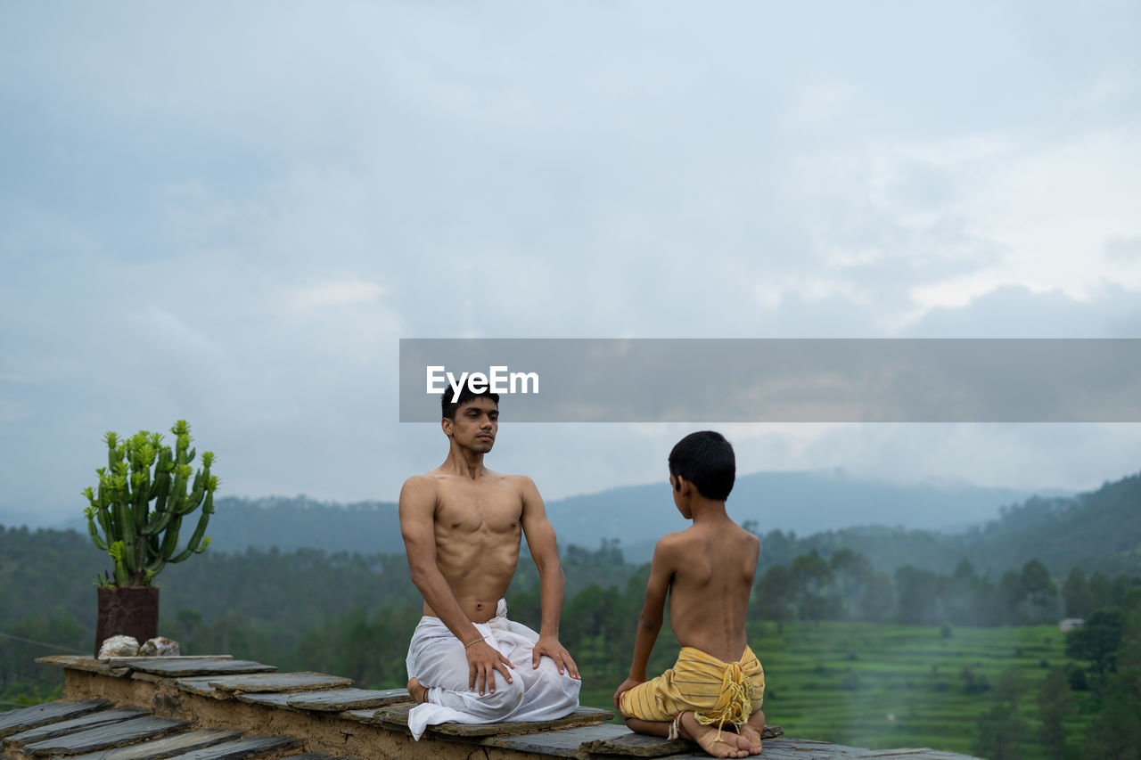 FRIENDS SITTING AGAINST SKY