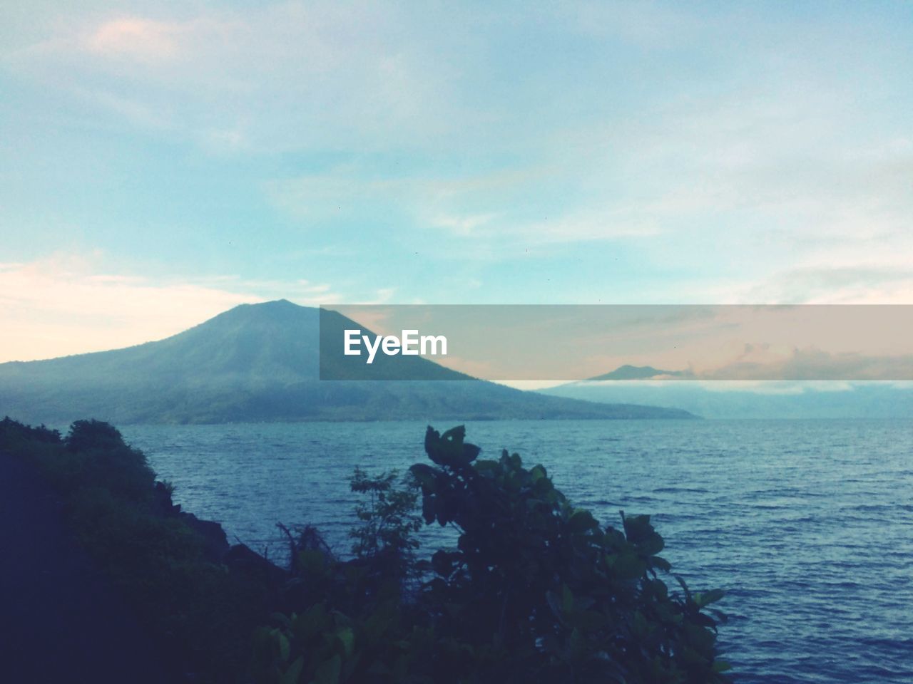 SCENIC VIEW OF SEA BY MOUNTAINS AGAINST SKY