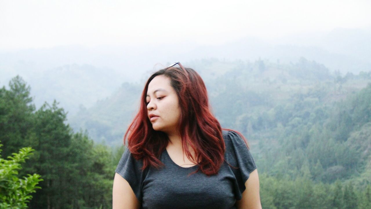 BEAUTIFUL YOUNG WOMAN LOOKING AT MOUNTAINS