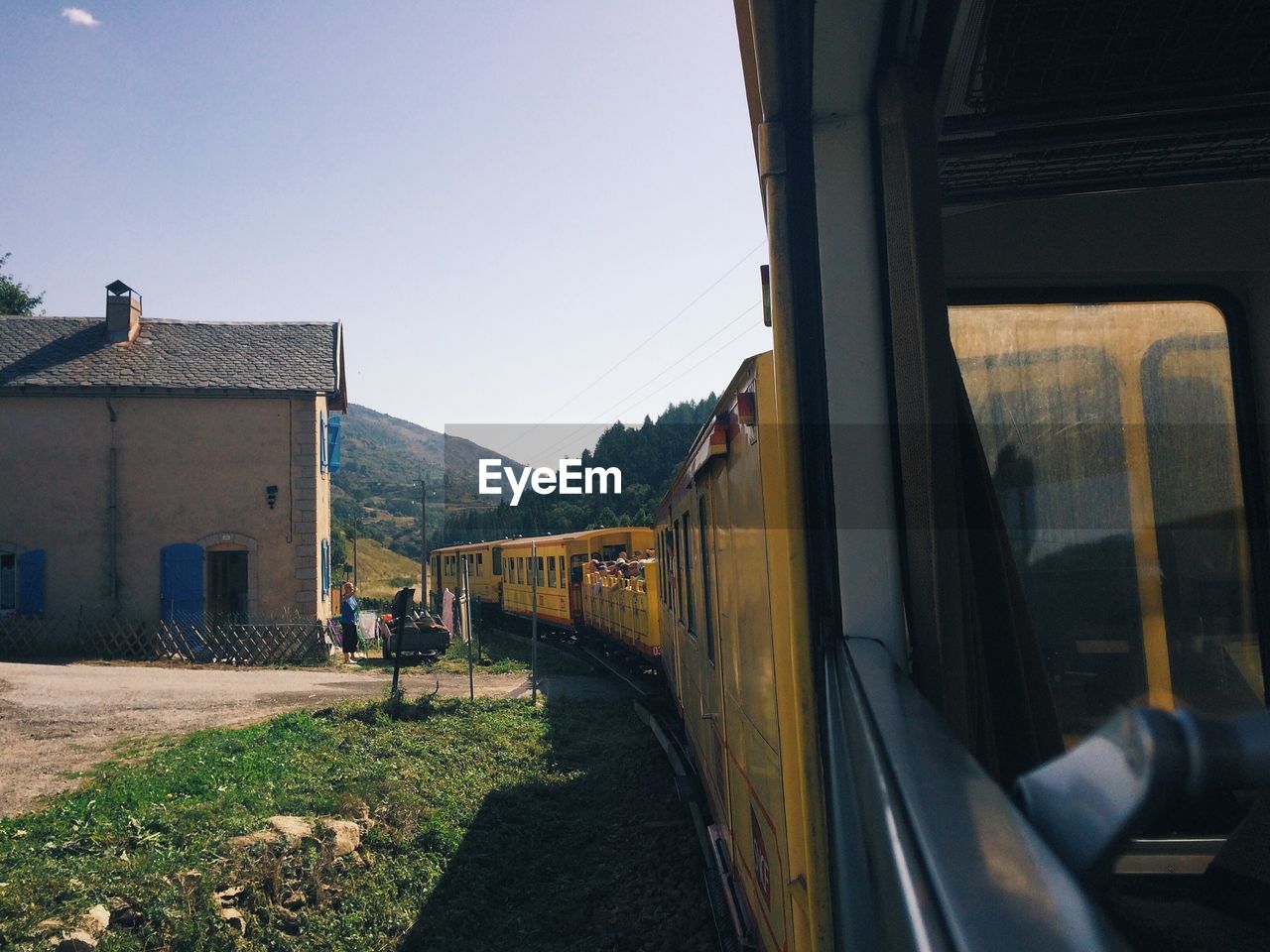 Yellow train moving against sky