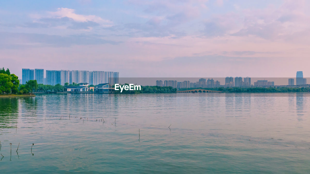 Buildings by sea against sky