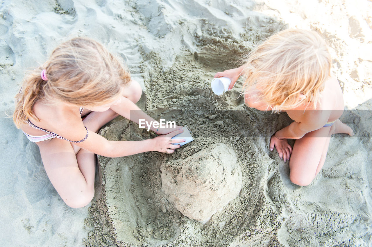 High angle view of sibling playing on beach