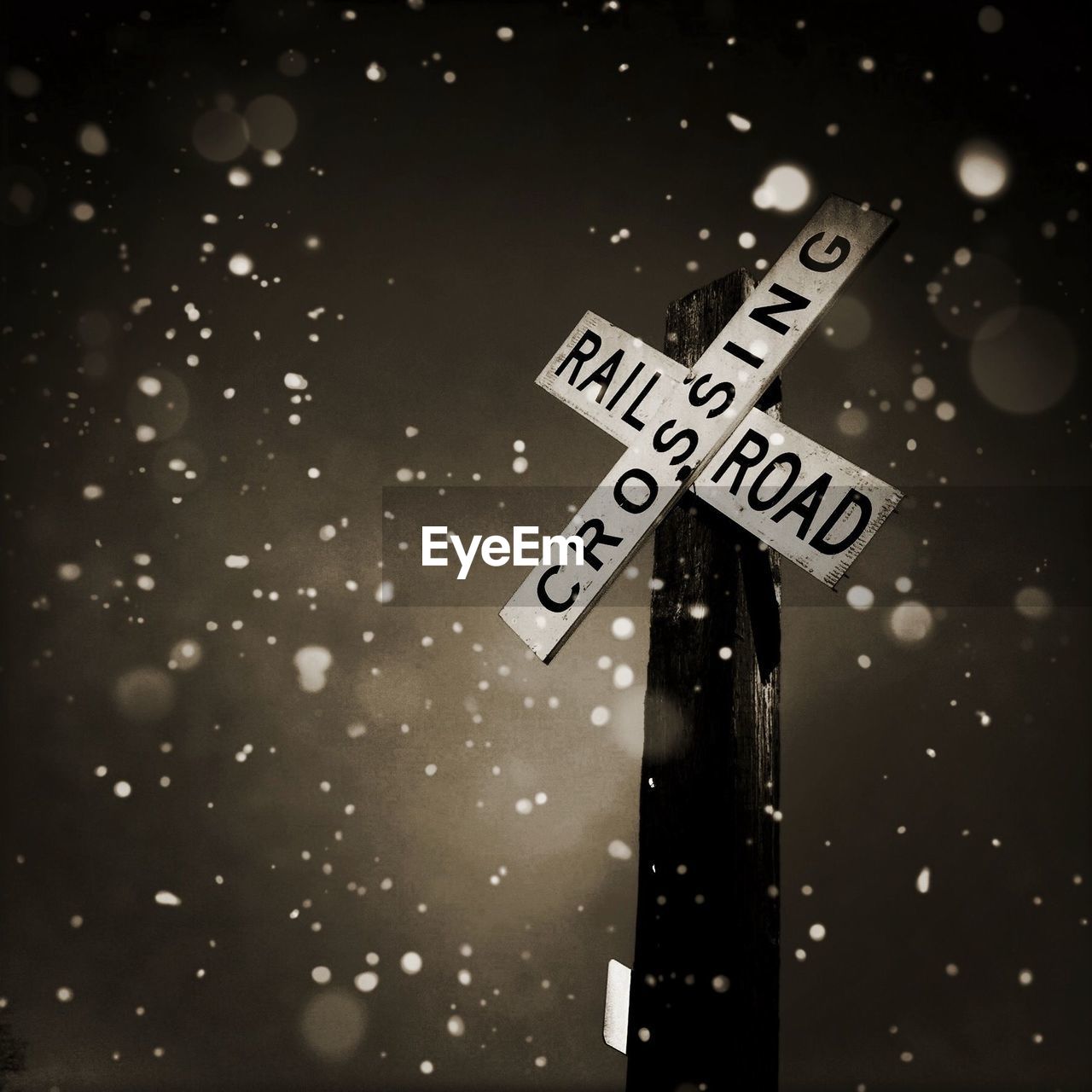 Railroad crossing sign in snow storm