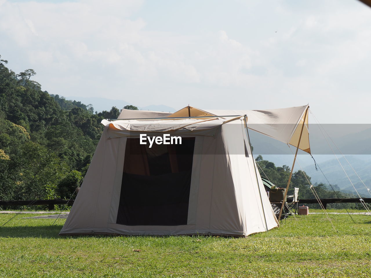 tent, grass, nature, plant, sky, camping, architecture, land, environment, built structure, no people, day, cloud, outdoors, landscape, field, tranquility, vacation, mountain, trip, building exterior, sunlight, travel, beauty in nature, scenics - nature, holiday, tree, summer, green