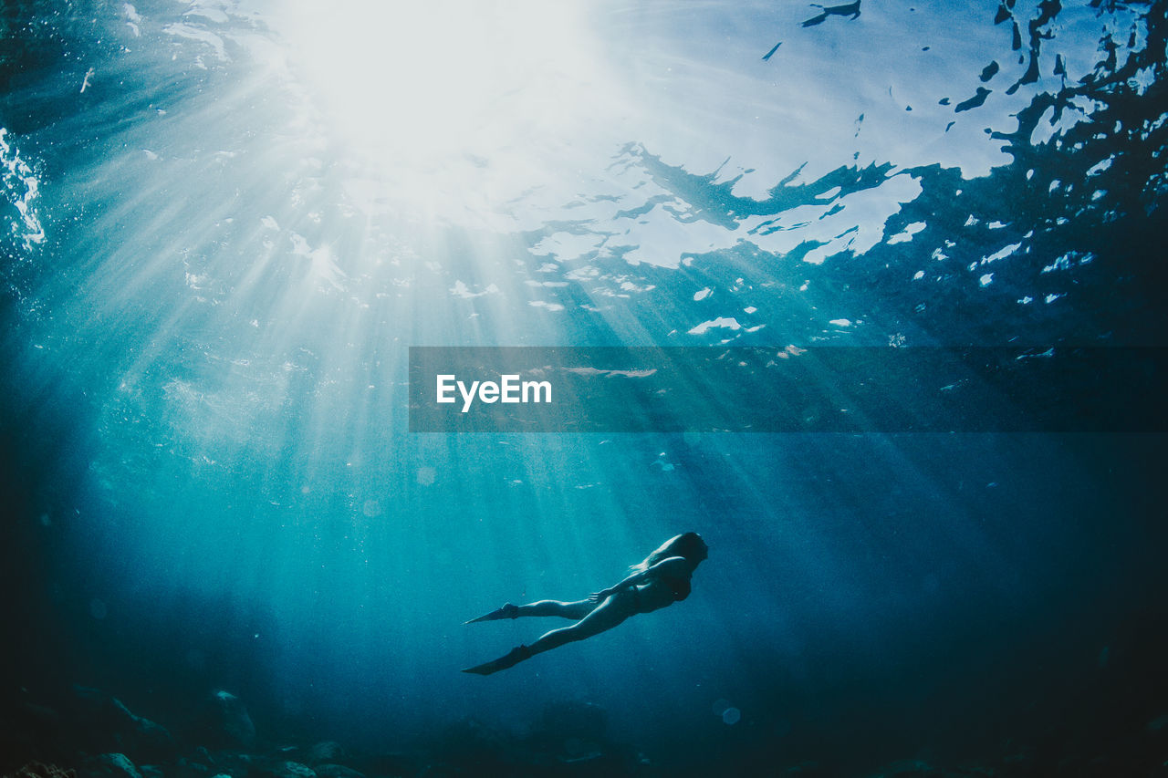 Low angle view of young woman swimming in sea