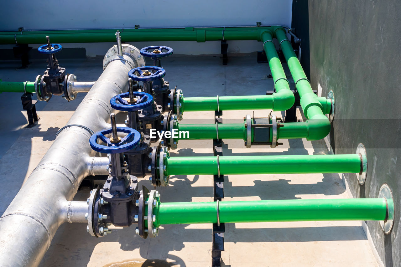 HIGH ANGLE VIEW OF PIPES ON INDUSTRY BY WATER