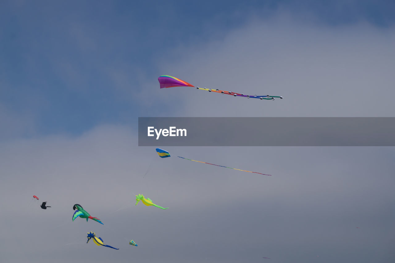 LOW ANGLE VIEW OF KITES FLYING IN SKY