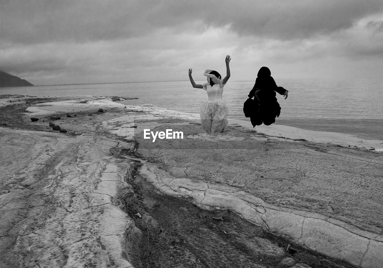 WOMEN ON BEACH AGAINST SKY