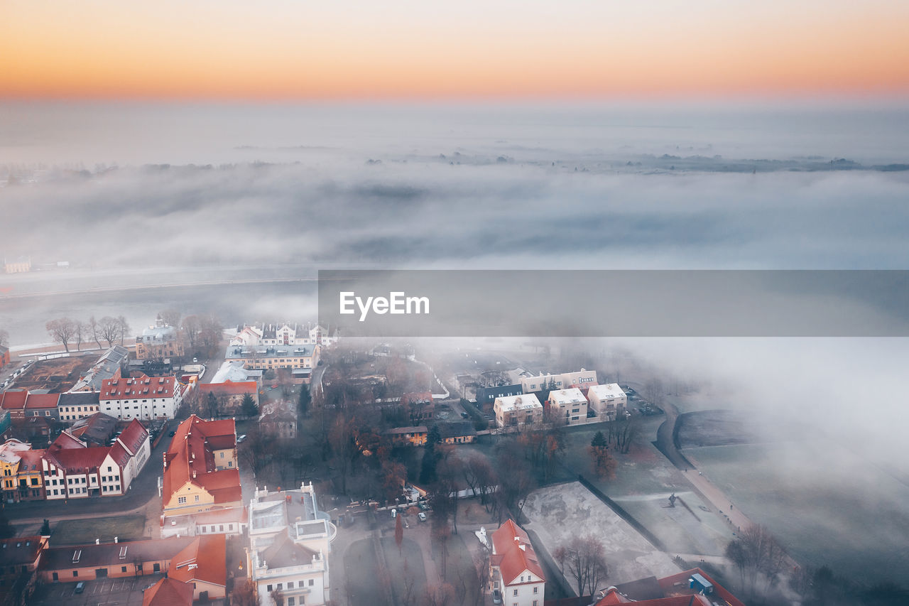 HIGH ANGLE VIEW OF BUILDINGS AGAINST SKY DURING SUNSET IN CITY