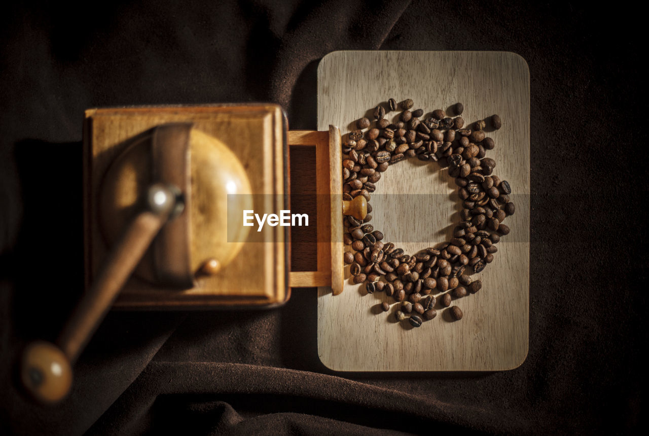 High angle view of coffee maker with beans on table in darkroom