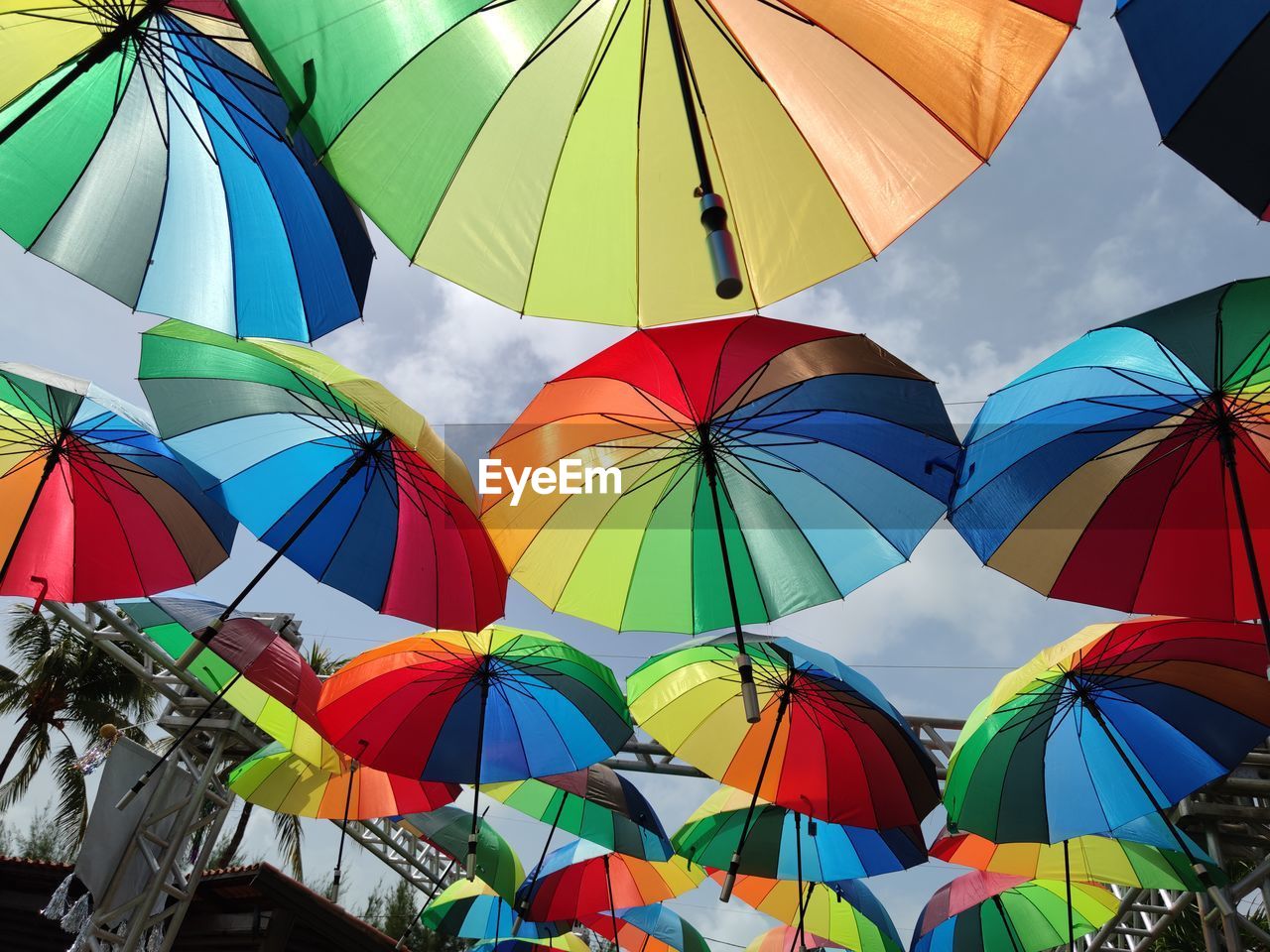 LOW ANGLE VIEW OF MULTI COLORED UMBRELLAS AGAINST SKY