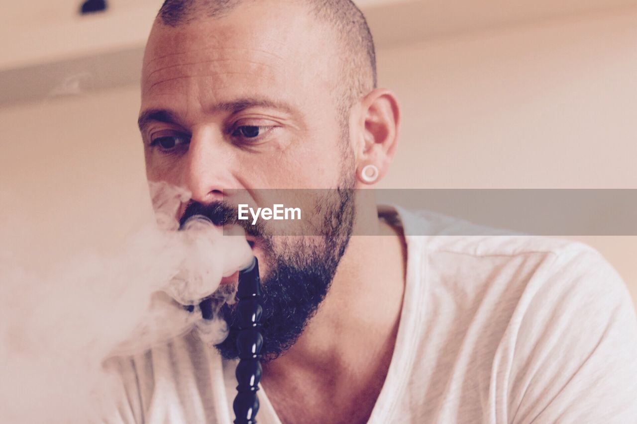 Portrait of man smoking water pipe