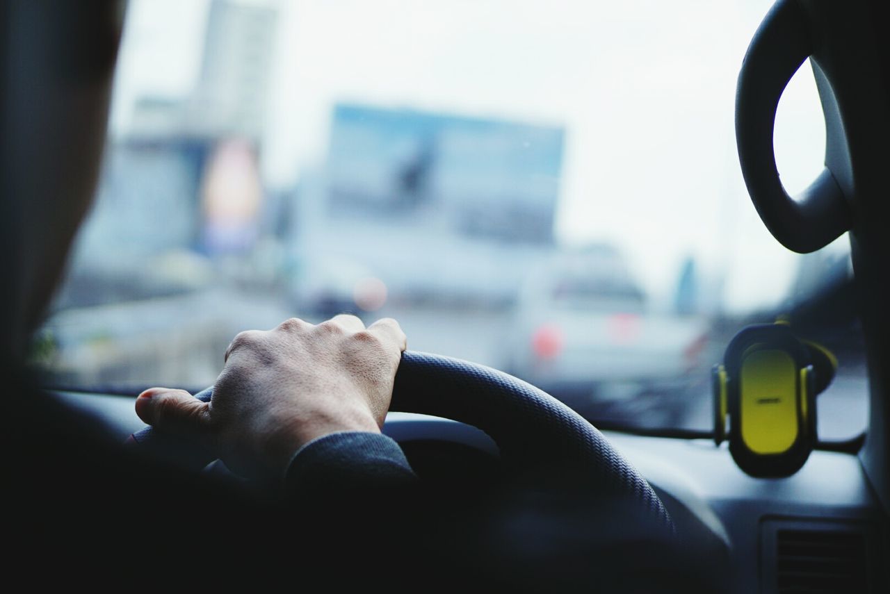 Cropped hand of person driving car