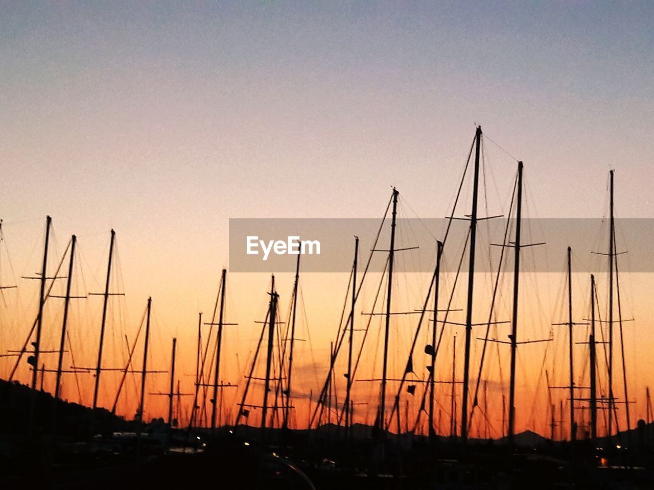 SILHOUETTE SAILBOATS IN MARINA AT SUNSET