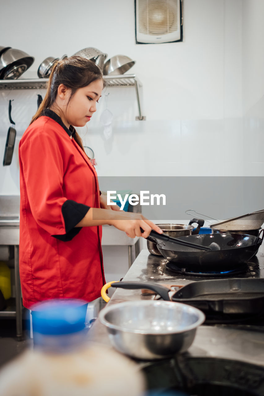 Side view of chef preparing food in kitchen