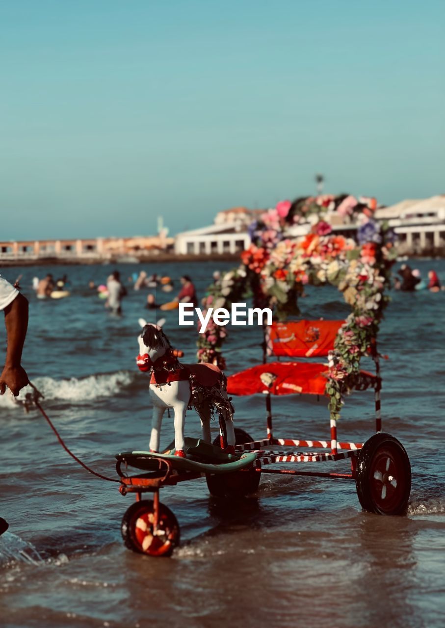 PEOPLE IN SEA AGAINST CLEAR SKY