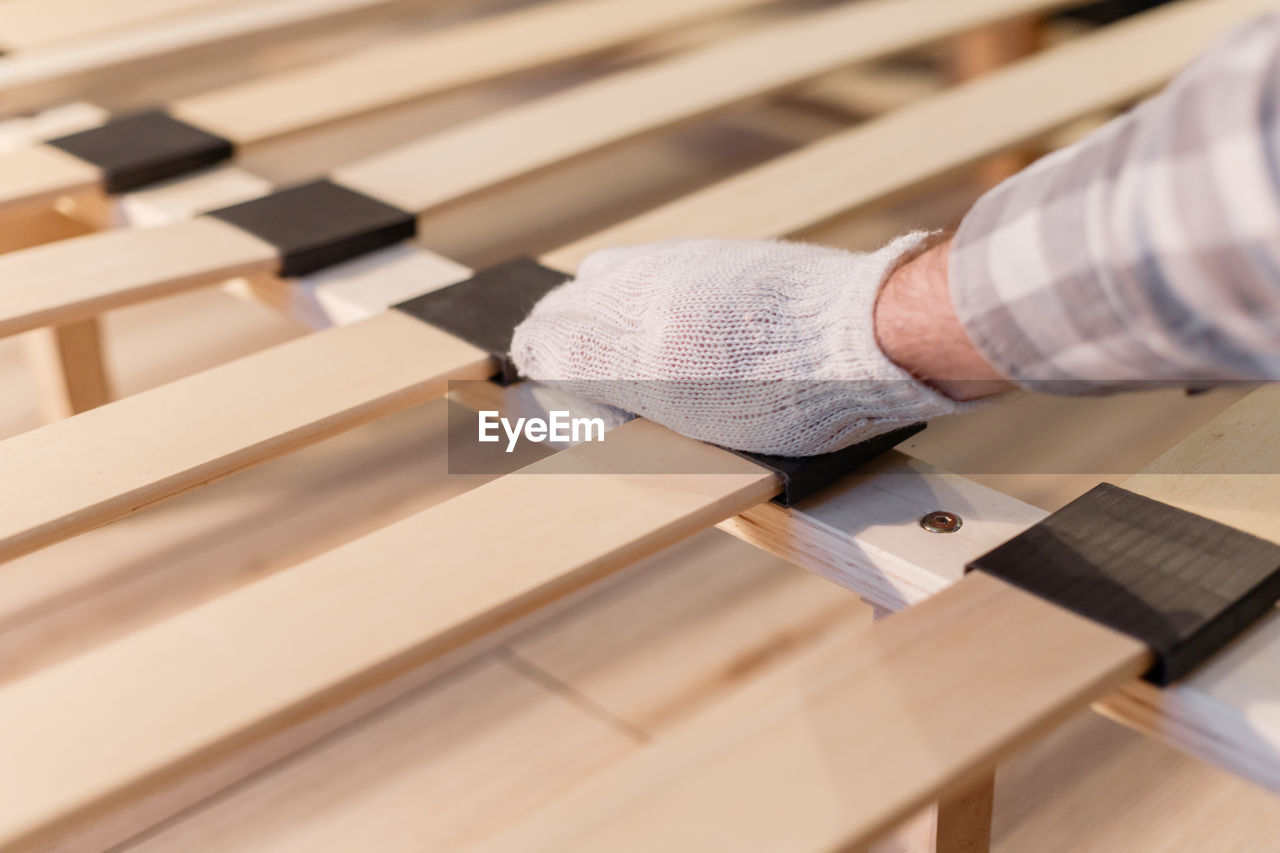 CLOSE-UP OF MAN WORKING ON WOODEN TABLE