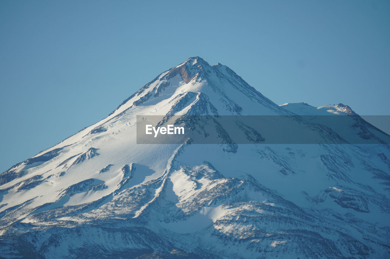 Scenic view of snowcapped mountains against clear sky