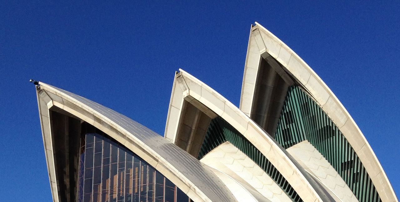 Low angle view of skyscraper against clear blue sky