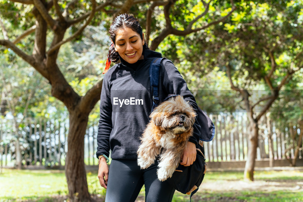 FULL LENGTH OF A YOUNG WOMAN WITH DOG