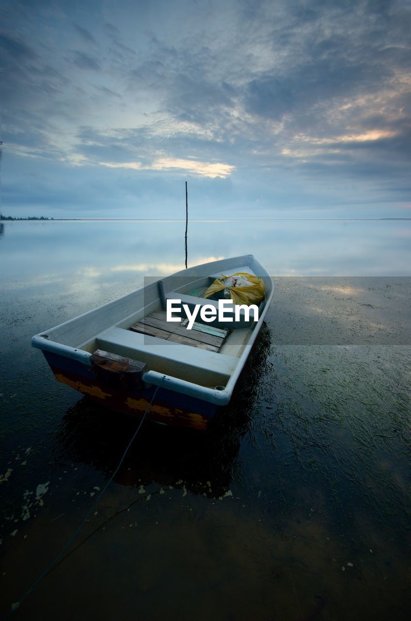 Boat moored on sea against sky