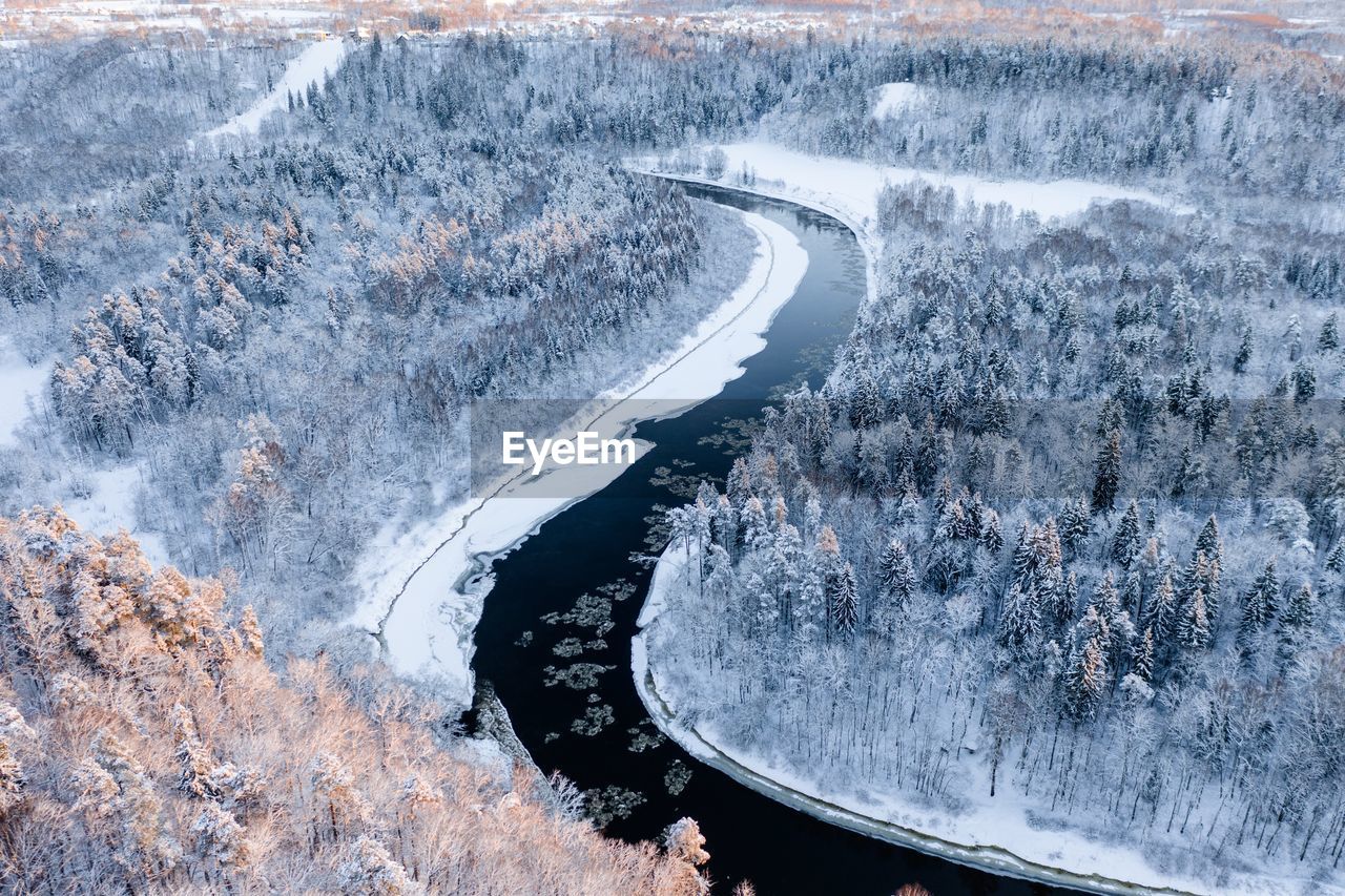 High angle view of river amidst snow covered landscape in forest