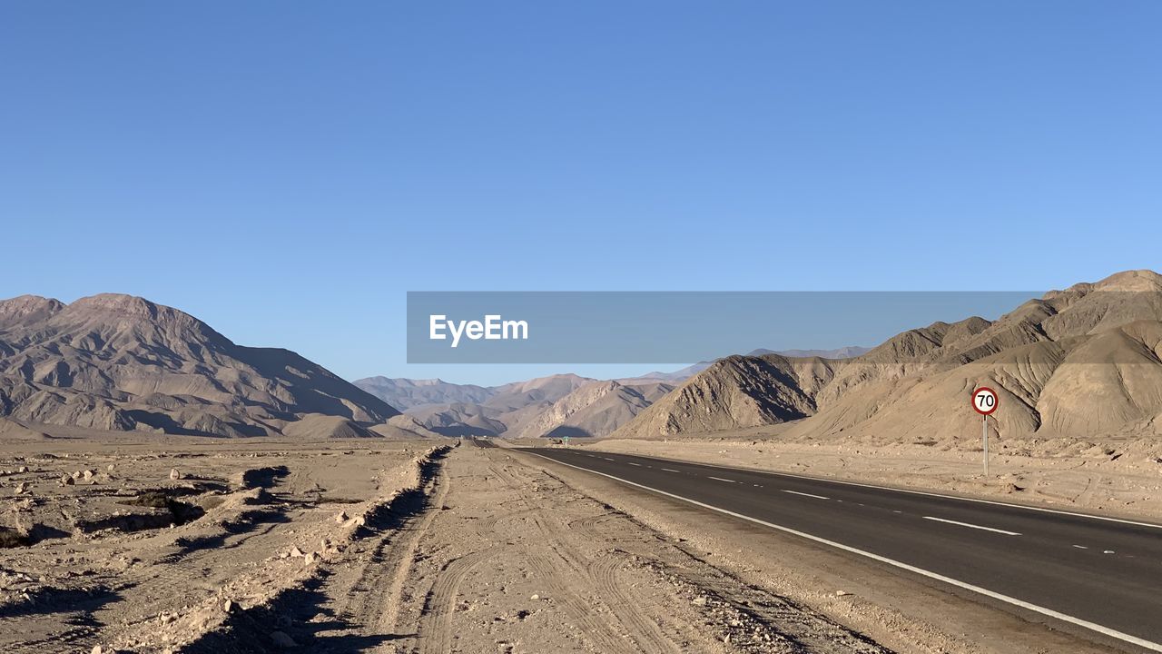 Scenic view of desert against clear blue sky