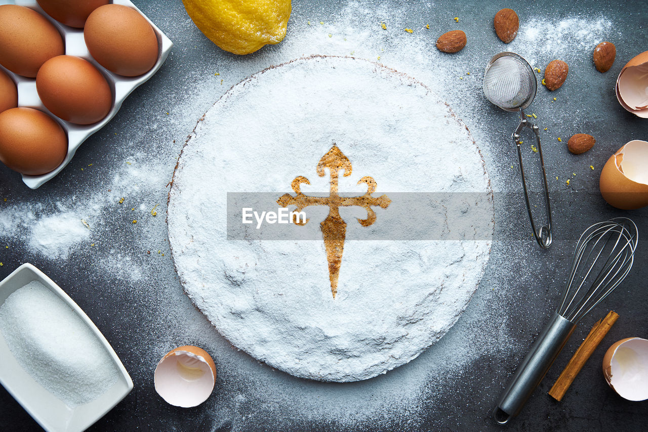 Still life of cake with ingredients, eggs, flour, lemon, almond and cinnamon. santiago cake