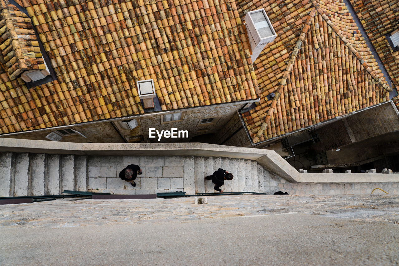 High angle view of people walking on stairs by rooftops