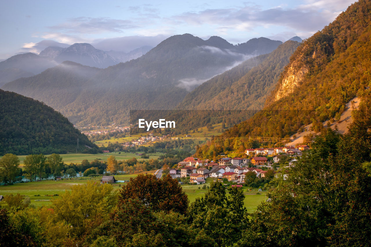 Panoramic view of julian alps at sunset with small towns in horizont