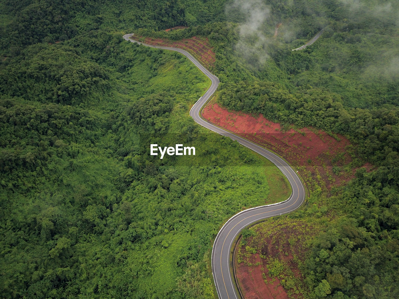 Countryside road passing through the lush green tropical rain forest mountain landscape