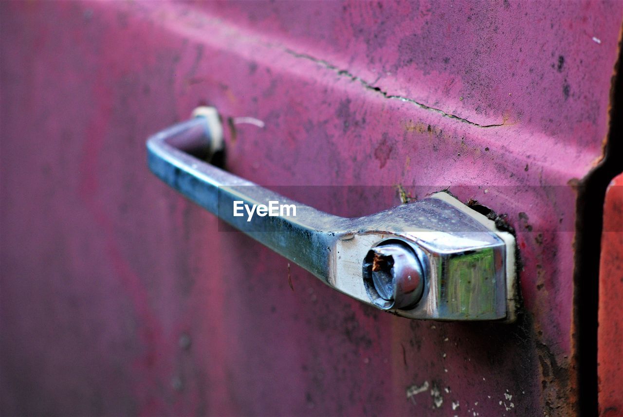 Close-up of rusty metallic handle on car door 