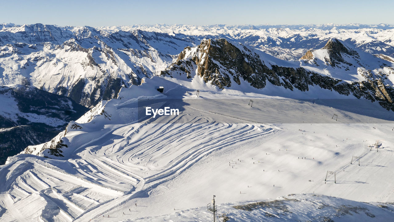 Ski tracks on white sunny snowed slopes of austrian alps