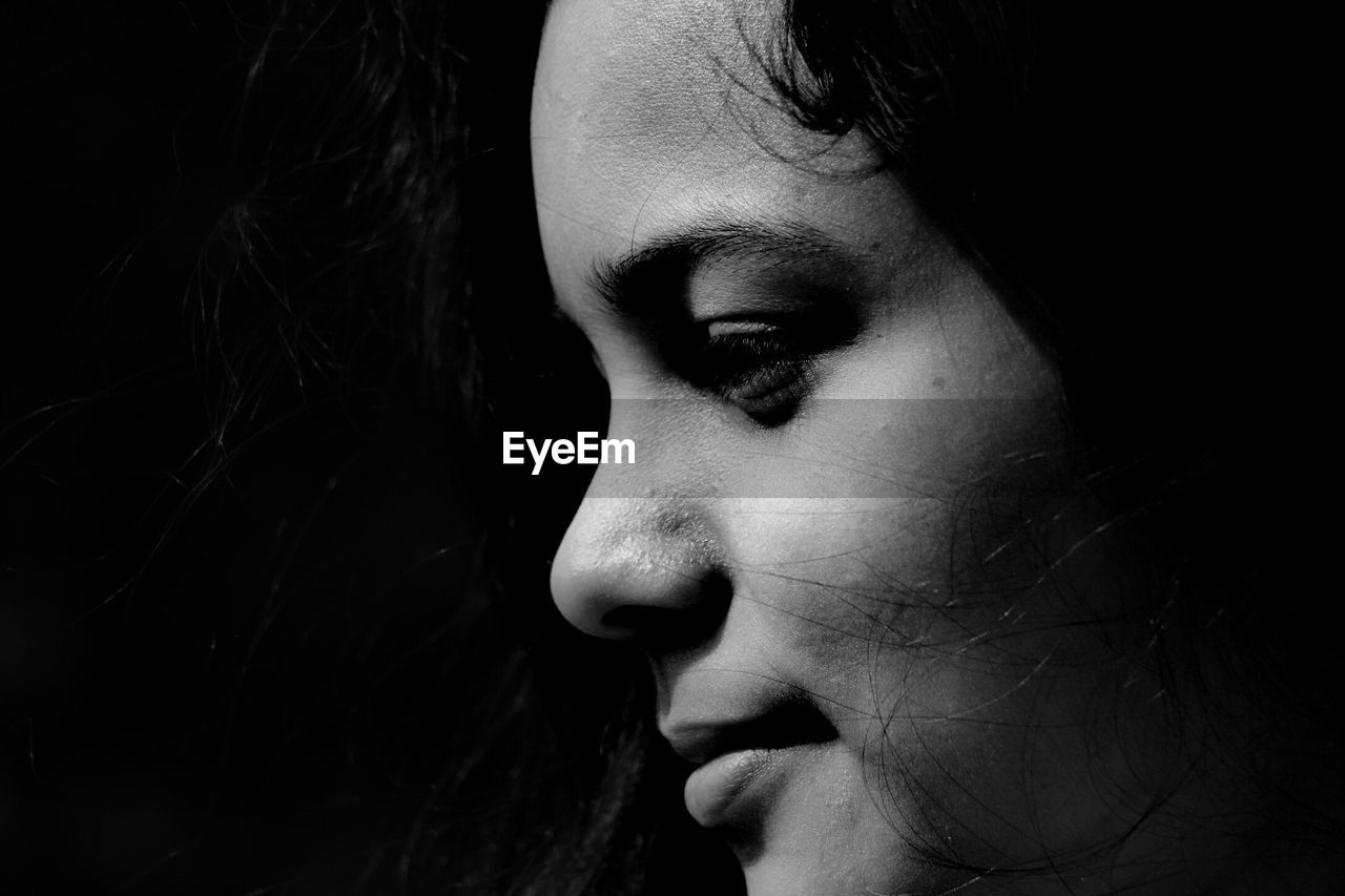 Close-up of smiling woman against black background