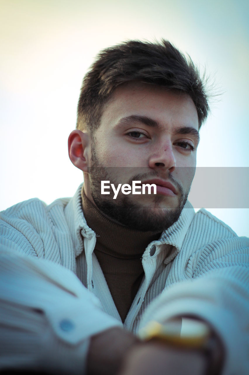 Portrait of young man against sky