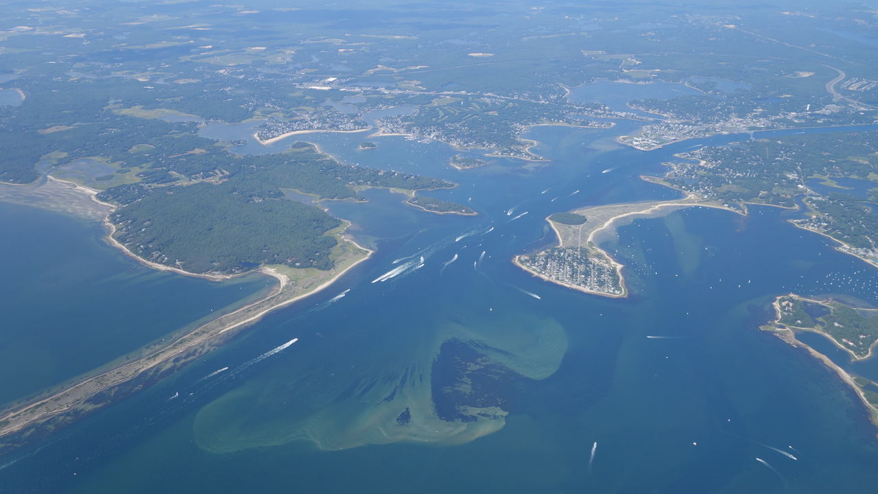 AERIAL VIEW OF SEA AND LANDSCAPE AGAINST BLUE SKY
