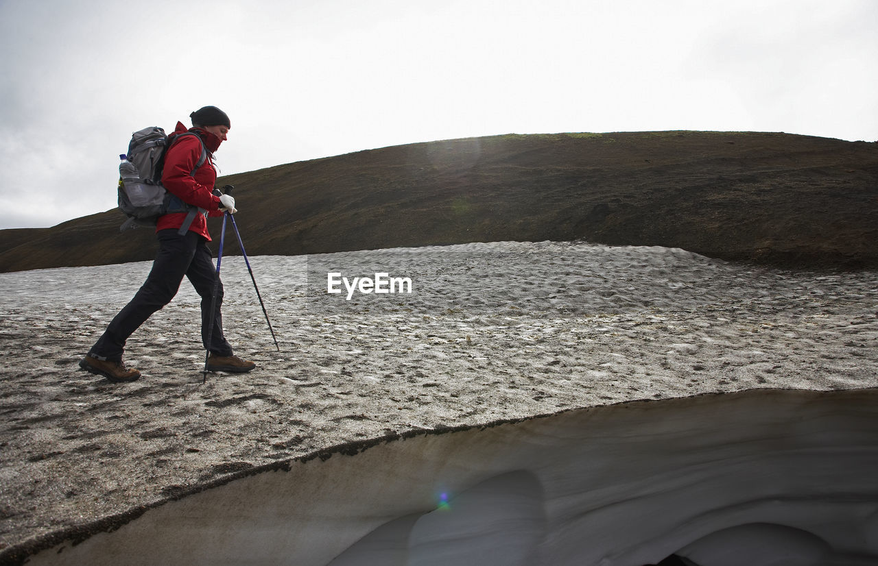 Woman crossing snowfield on the laugavegur hiking trail