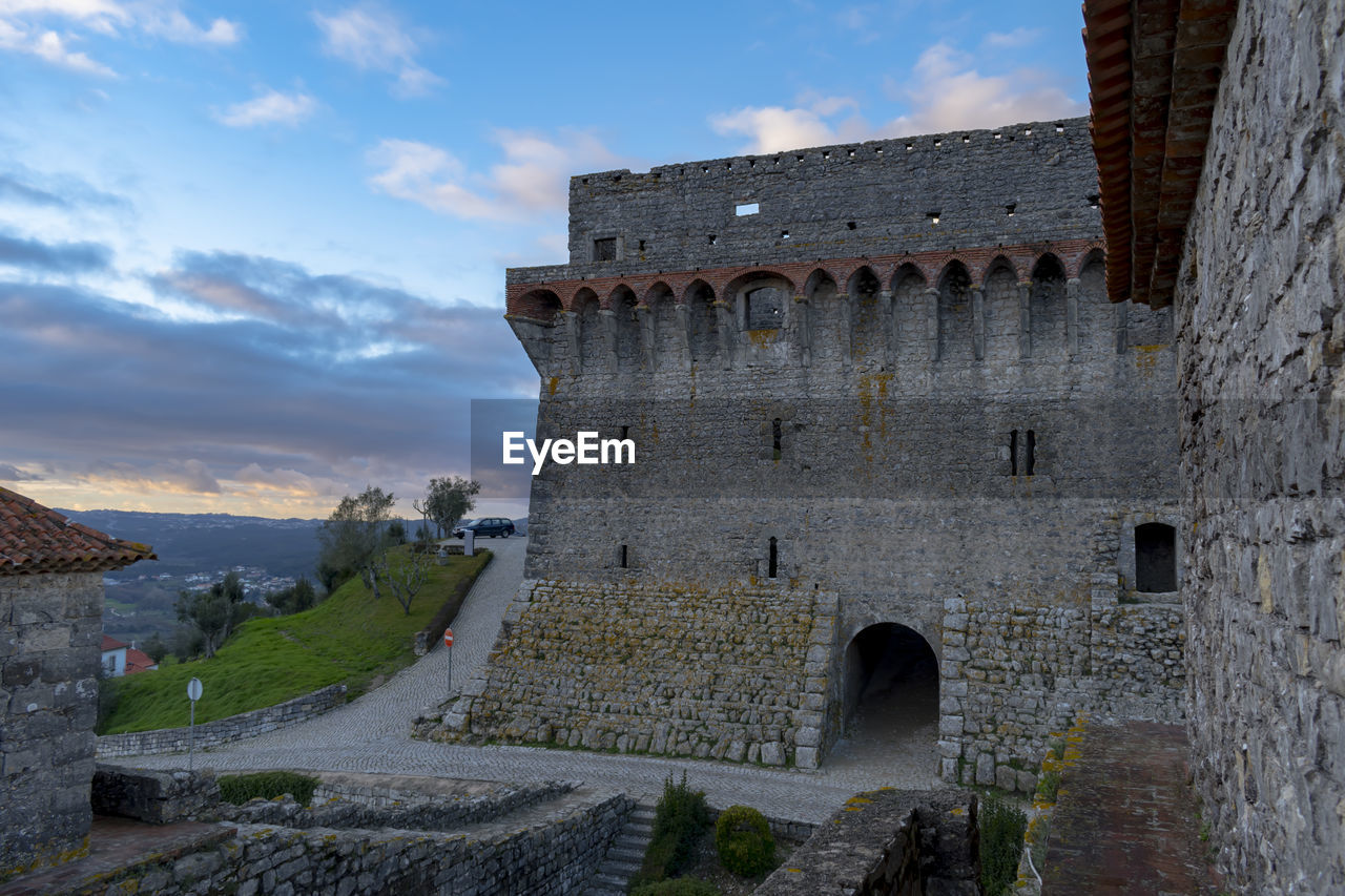 Low angle view of old ruin building against cloudy sky