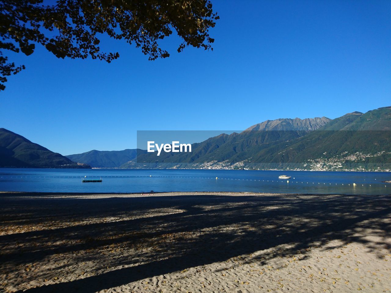 View of calm blue sea against mountain range