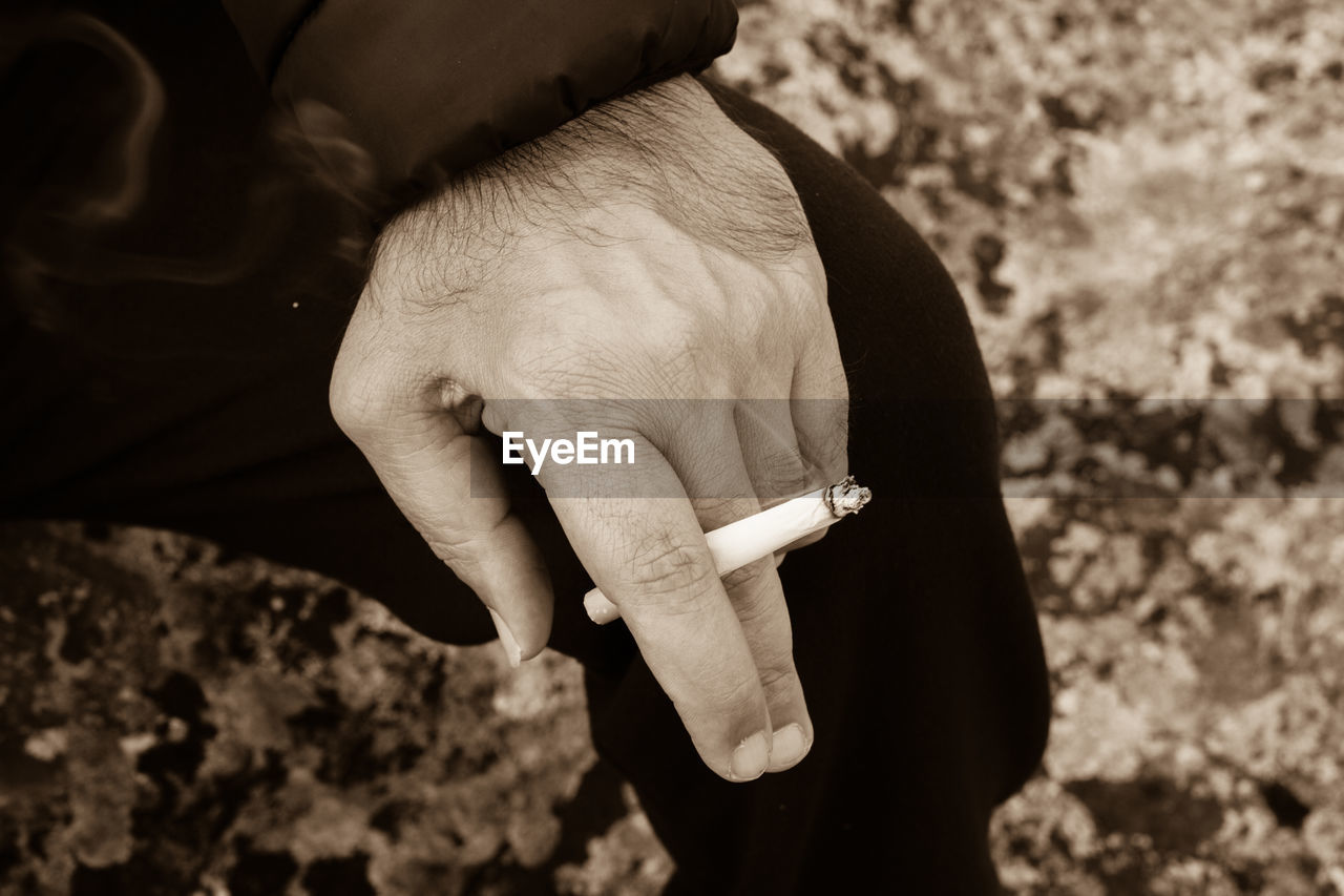 Close-up of man holding cigarette