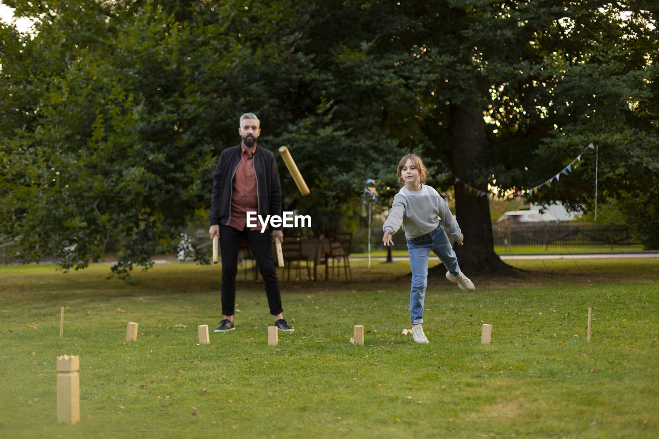 Father and daughter playing molkky game in park