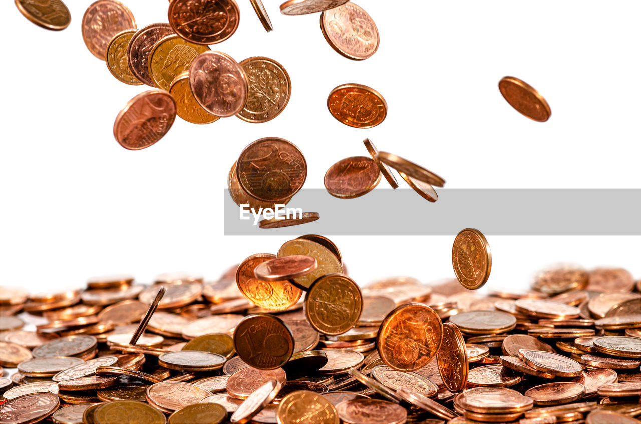 Cent coins fall of a heap of cent coins, white background, isolated, money rain