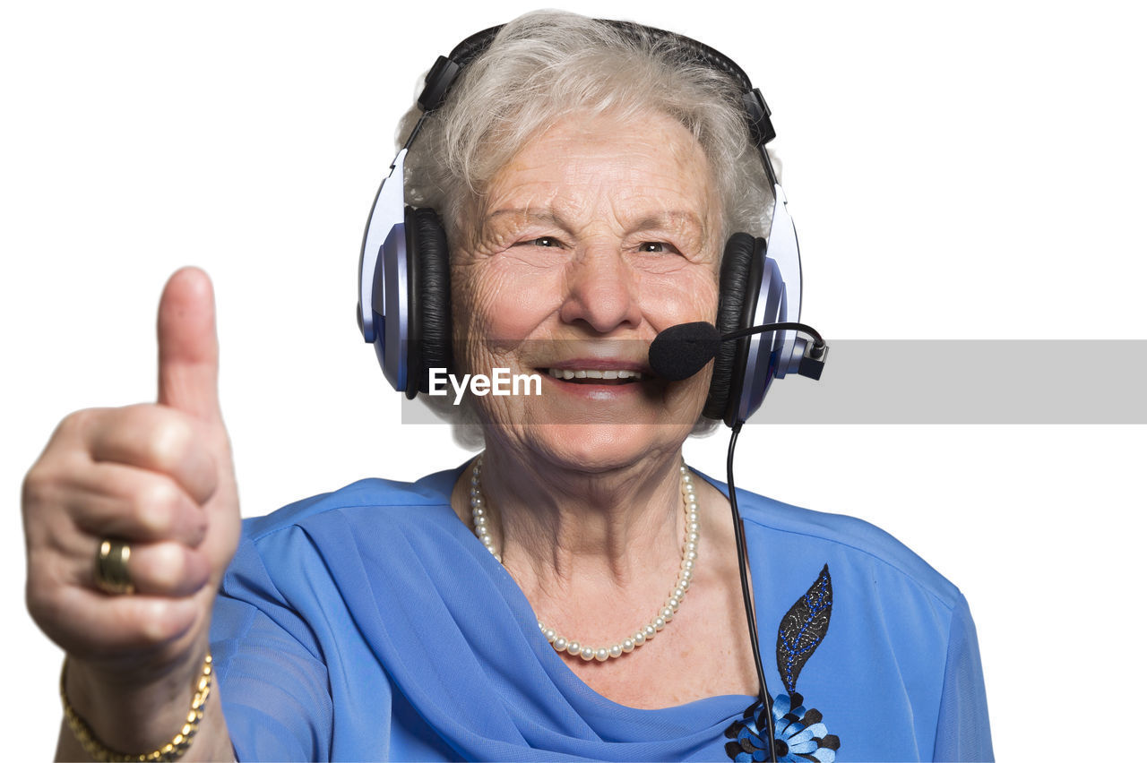 Funny senior citizen talks to her family via head set during quarantine. she shows thumbs