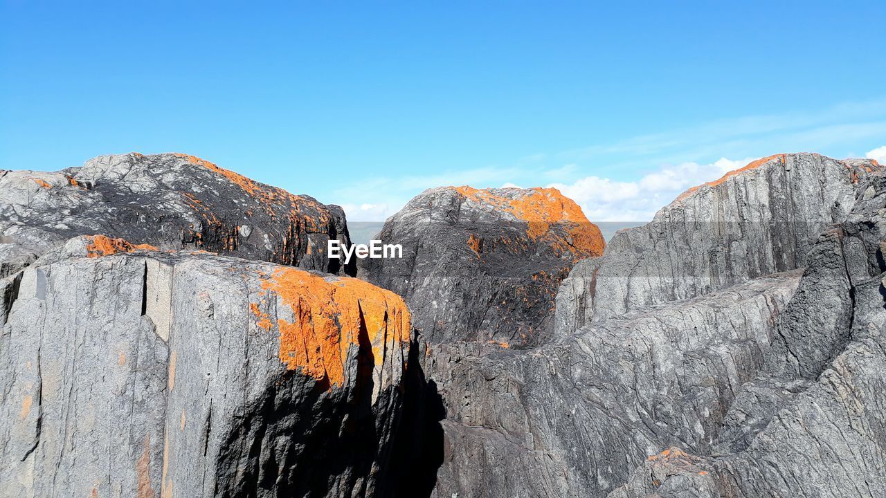 PANORAMIC VIEW OF ROCK FORMATIONS AGAINST BLUE SKY