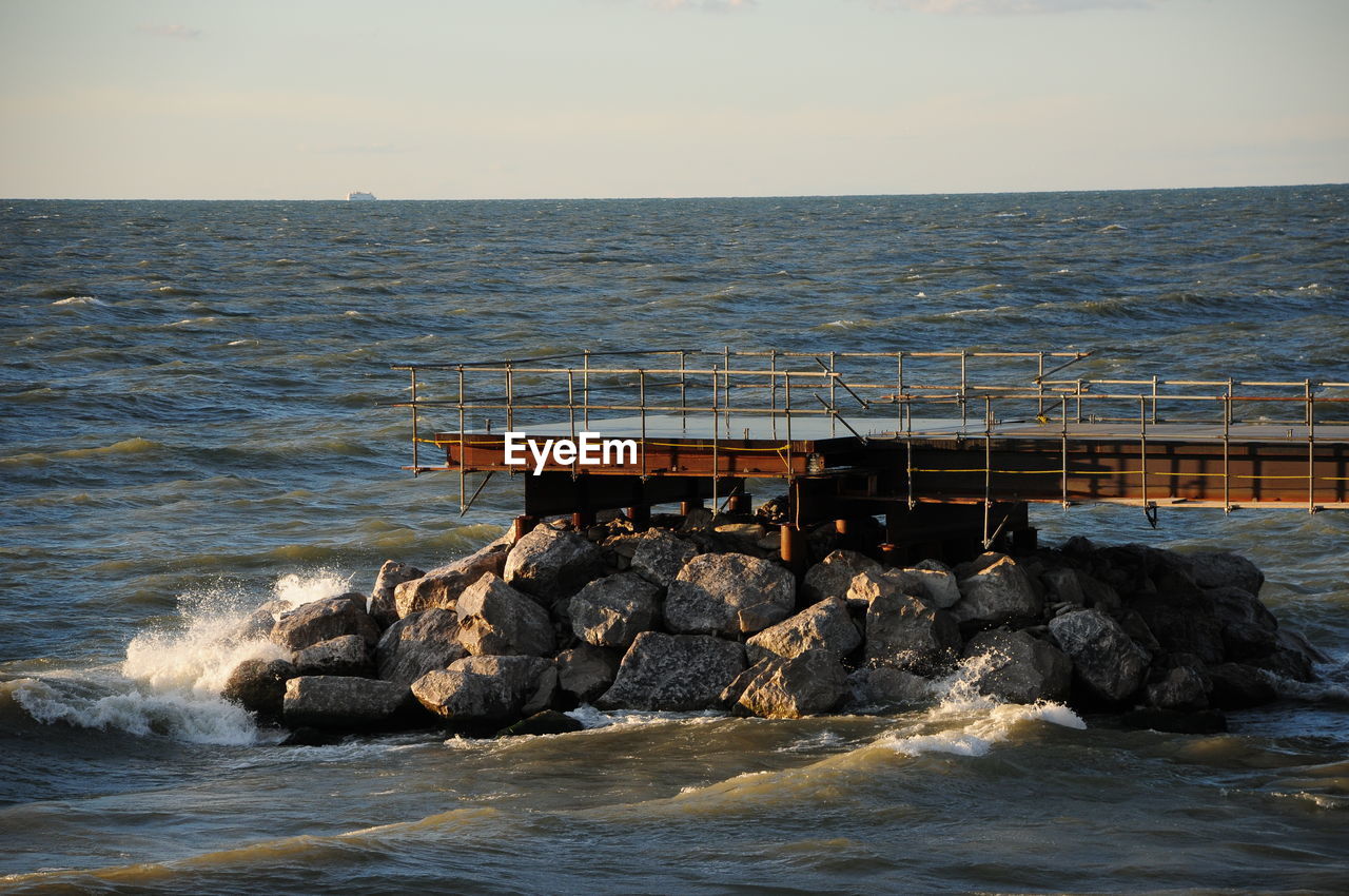 SCENIC VIEW OF ROCKS AT SEA AGAINST SKY