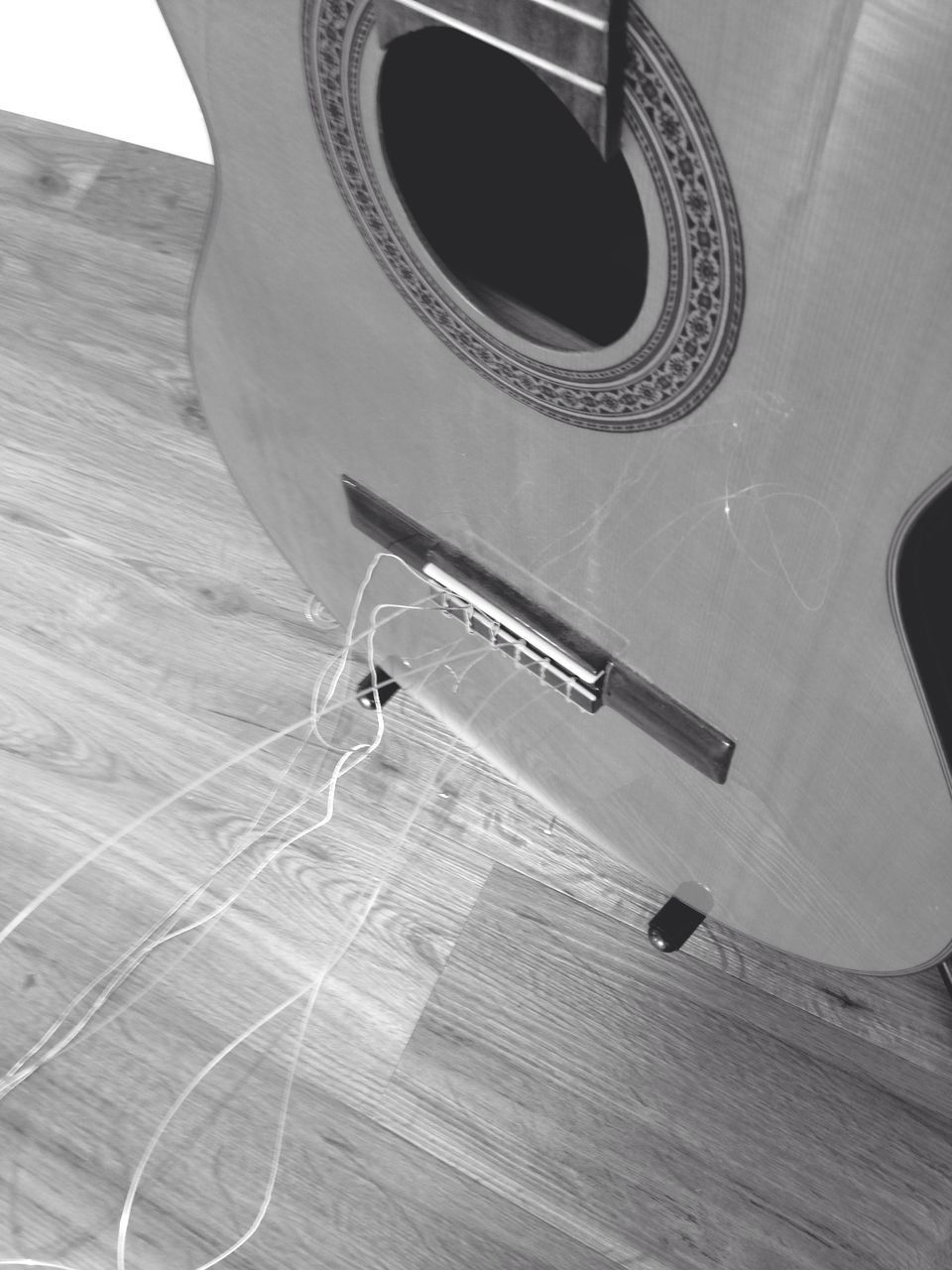 High angle view of damaged strings of acoustic guitar
