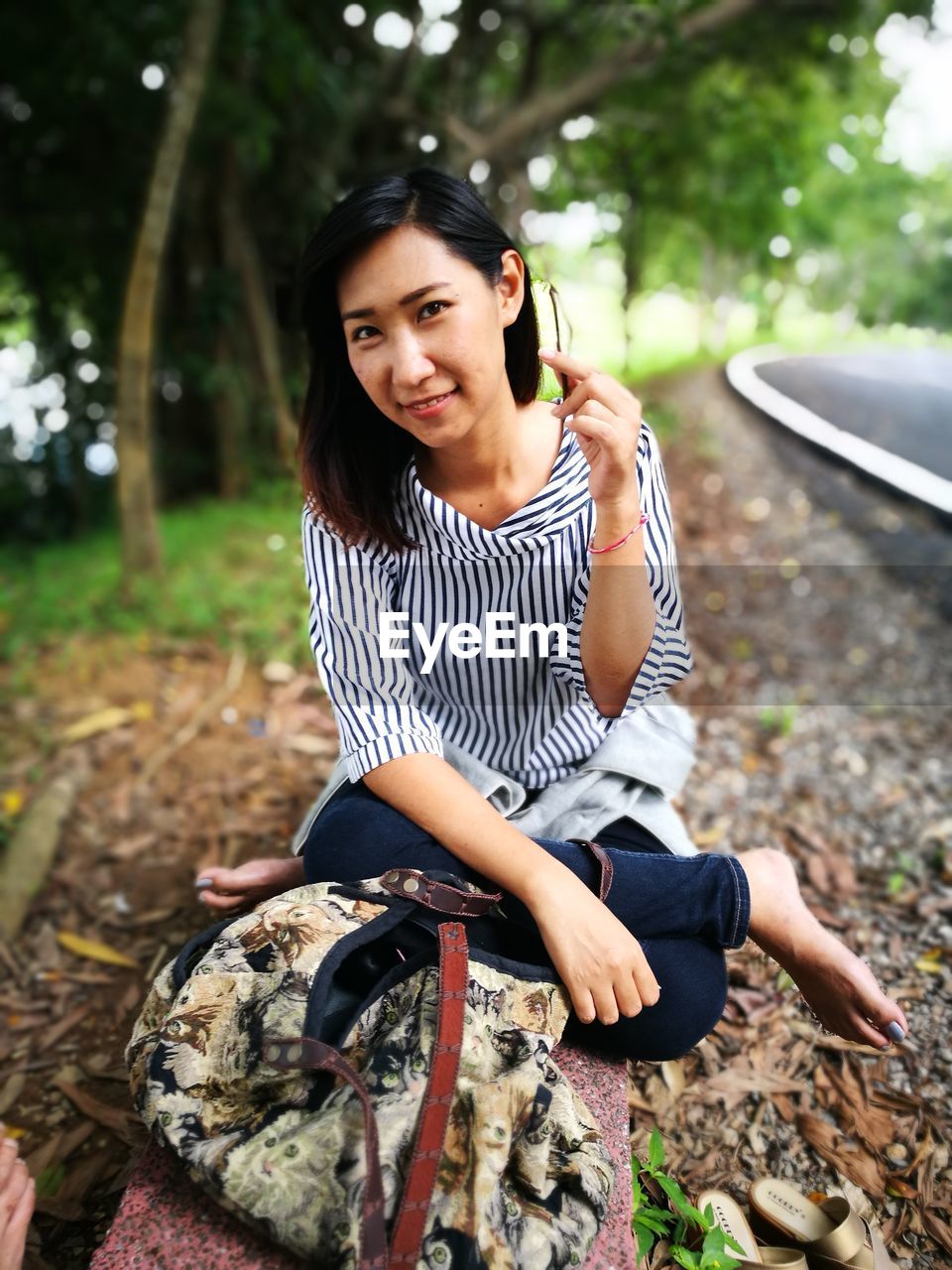 Portrait of woman sitting by backpack on bench